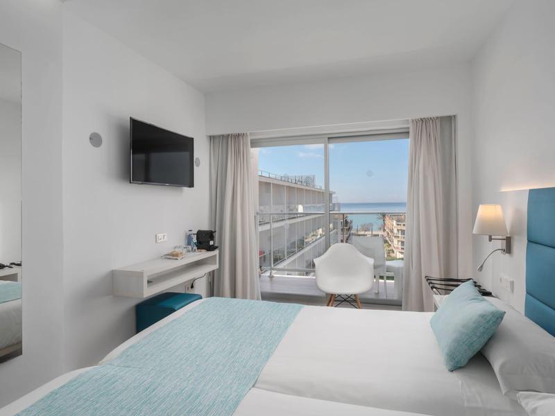 Camera d'hotel moderna con vista mare, letto matrimoniale, TV a schermo piatto e balcone