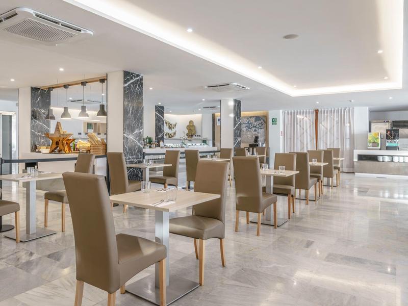 Ristorante moderno e luminoso con sedie comode e tavoli in marmo in un hotel.