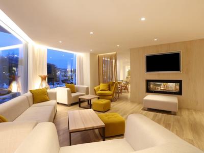 Modernes Wohnzimmer mit gemütlichen Sofas, gelben Sesseln, Holztisch und Kamin unter Fernseher.