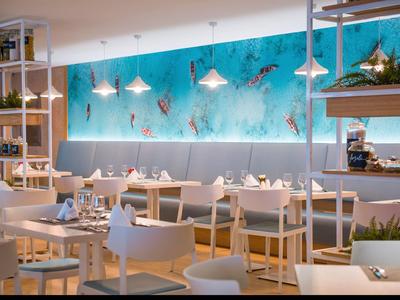 Modernes Restaurant mit weißen Stühlen, Holztischen und einer blauen Wand mit Meeresmotiven.