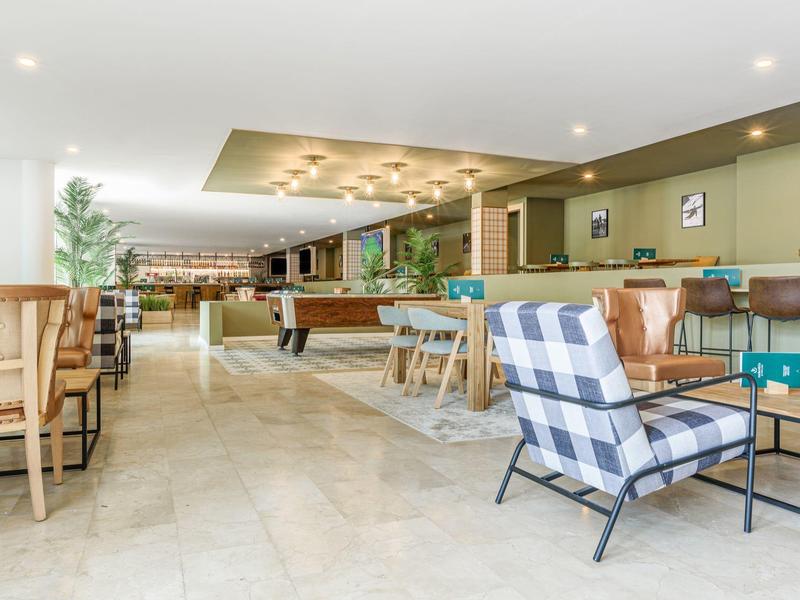 Ampio soggiorno dell'hotel con poltrone, tavolini e biliardo.