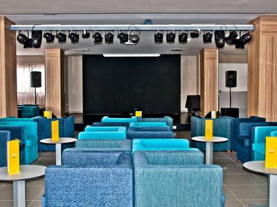 Spazio per eventi moderno con panche blu e un piccolo palcoscenico