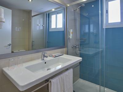 Modern bathroom with large mirror, sink, and glass shower cabin