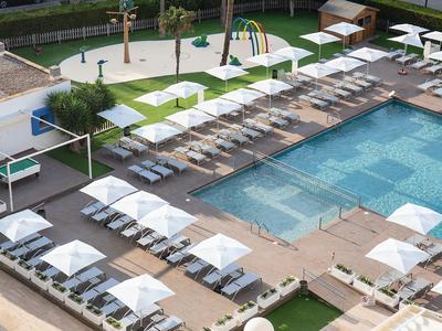 Modern hotel pool with lounge chairs and umbrellas in a sunny setting