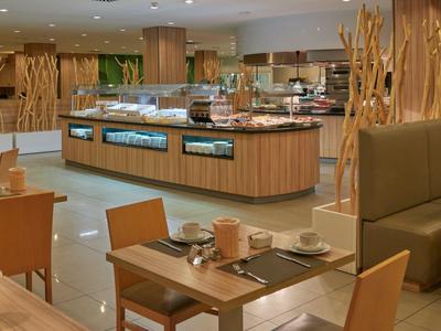 Modern, bright buffet restaurant with wooden furniture and spacious food display.