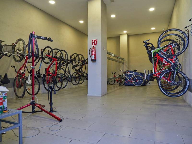 Interior space with several bikes hanging on the wall and bright flooring.