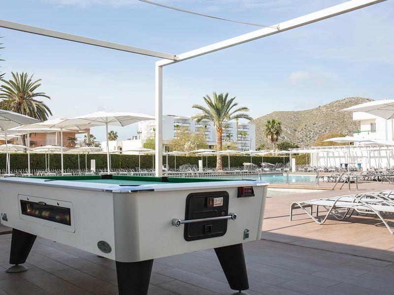 Pool table on a terrace with pool and sun loungers in sunny weather