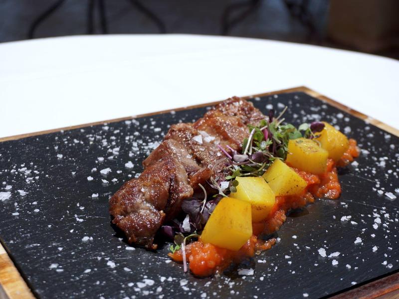 Viande grillée avec légumes sur planche en pierre noire avec sel gros.