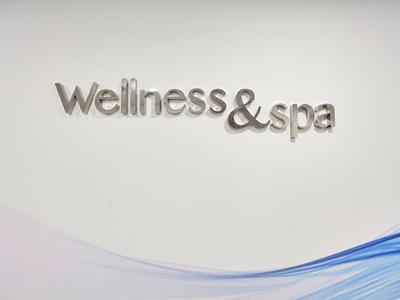 Wall signage with the words Wellness & spa in metal letters.