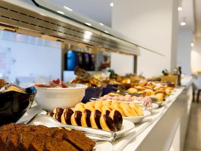 Buffet with a variety of dishes in a bright, modern dining area.