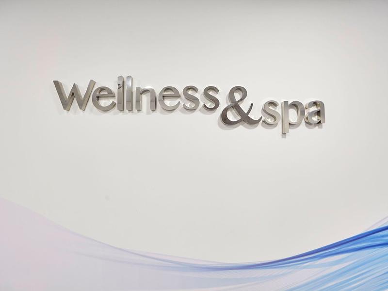 Wall signage with the words Wellness & spa in metal letters.