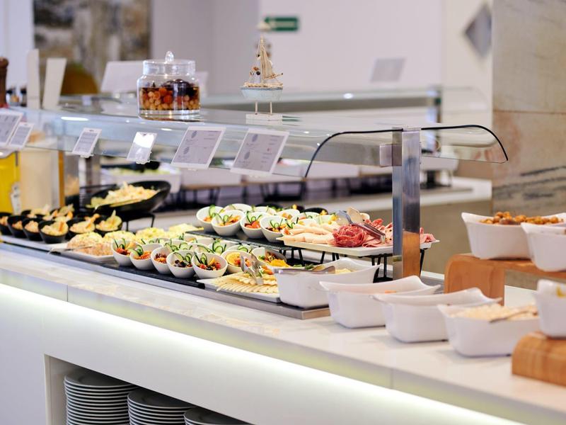 Stół bufetu z różnorodnymi potrawami w małych miseczkach i talerzach.