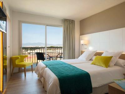 Nowoczesny pokój hotelowy z łóżkiem podwójnym, balkonem i widokiem na góry.