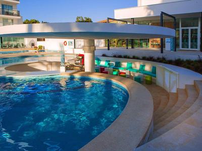 Basen z wbudowanym barem i schodami na zewnątrz hotelu.