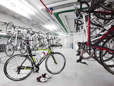 Nowoczesne pomieszczenie na rowery z rowerami szosowymi i kaskami w jasnej piwnicy.