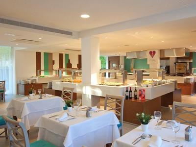 Jasna restauracja z białymi nakryciami i nowoczesnym wystrojem w hotelu.