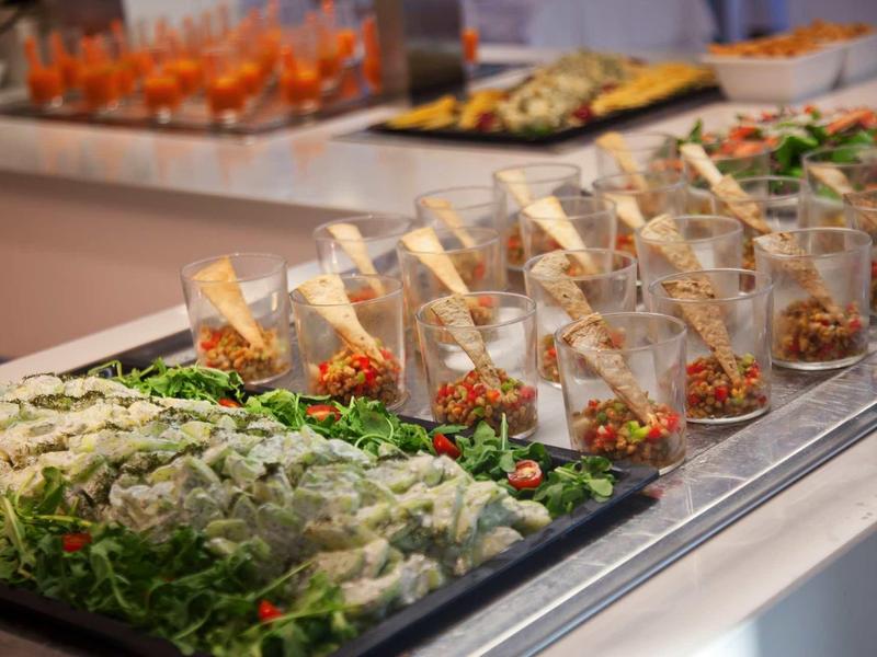 Bufet z różnymi przekąskami podanymi w szklankach i świeżymi składnikami.