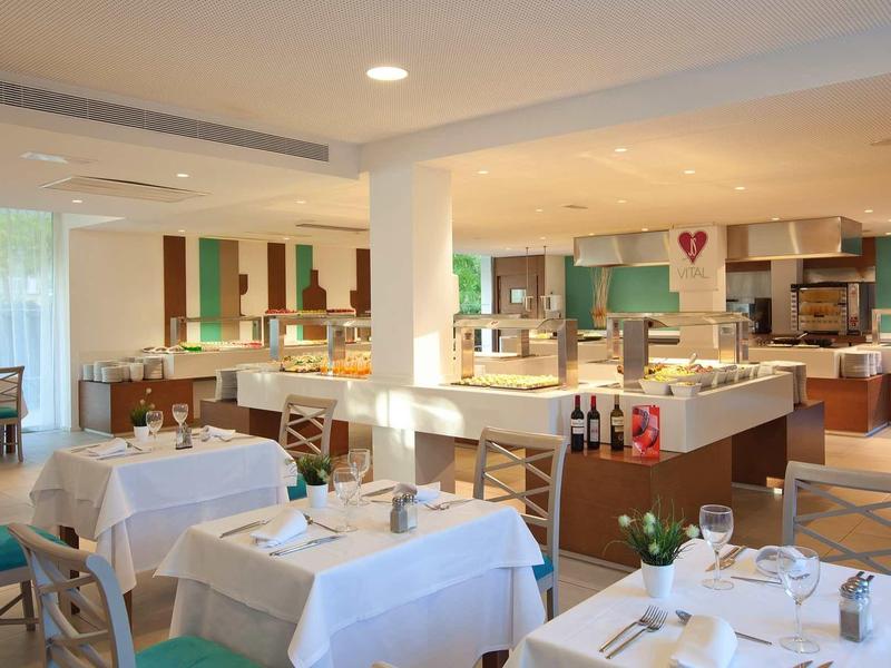 Jasna restauracja z białymi nakryciami i nowoczesnym wystrojem w hotelu.