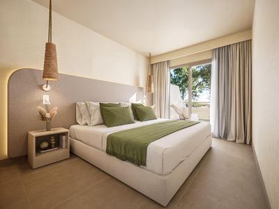 Modernes Hotelzimmer mit Doppelbett, grünen Akzenten und großem Fenster mit Blick auf Bäume.