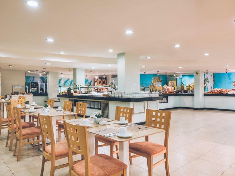 Jasna, nowoczesna sala jadalna z drewnianymi krzesłami i bufetami przy ścianie.