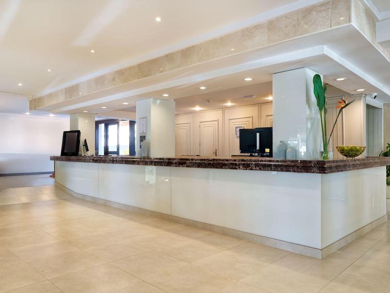 Bagno moderno con grande specchio, lavabo e doccia a filo pavimento.