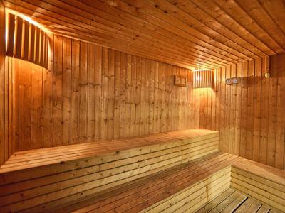Cozy sauna room with wooden walls, benches, and soft lighting