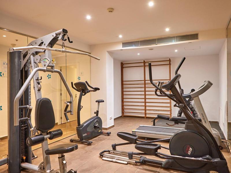 Modern gym room with various exercise machines in a well-lit space.
