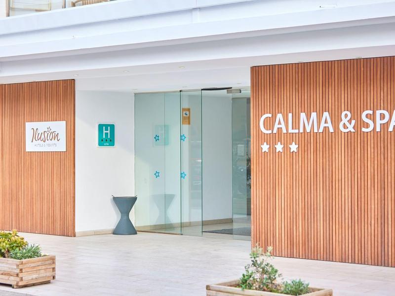 Modern hotel entrance with wood paneling and Calma & Spa sign