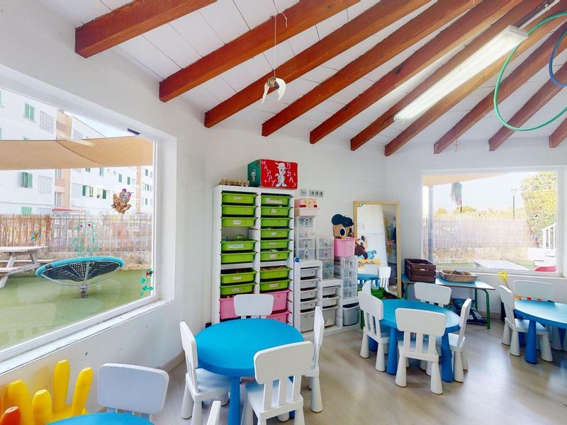 Jasny, nowoczesny pokój zabaw dla dzieci z kolorowymi stolikami, krzesłami i zabawkami w hotelu.