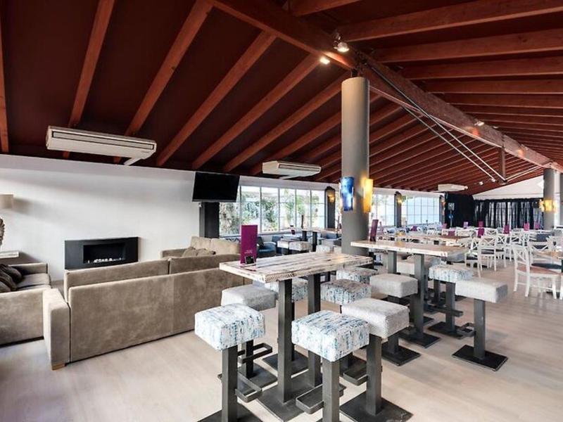 Nowoczesna restauracja hotelowa z wygodnymi miejscami do siedzenia i dużymi oknami wpuszczającymi dużo światła dziennego.