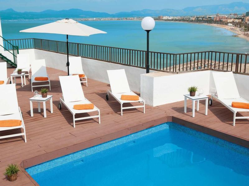 Rooftop terrace with pool, sun loungers, and sea view.