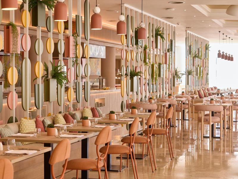 Modern restaurant met houten stoelen, tafels en decoratieve wandobjecten.