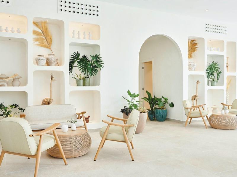 Jasny, nowoczesny pokój hotelowy z zaokrąglonymi półkami i naturalną dekoracją.