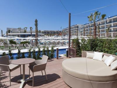 Moderner Balkon mit Holzterrasse, Rundsofa, Stühlen, Tischen und Blick auf moderne Wohngebäude.