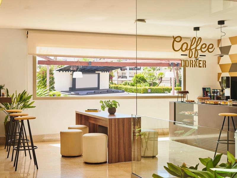 Bright and modern coffee corner with seating and large window front.