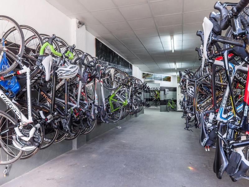 Bike room with many bicycles hanging on walls in a clean, well-lit space.