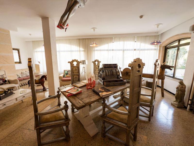 Rustic dining area with sturdy wooden furniture and large windows in a bright room.