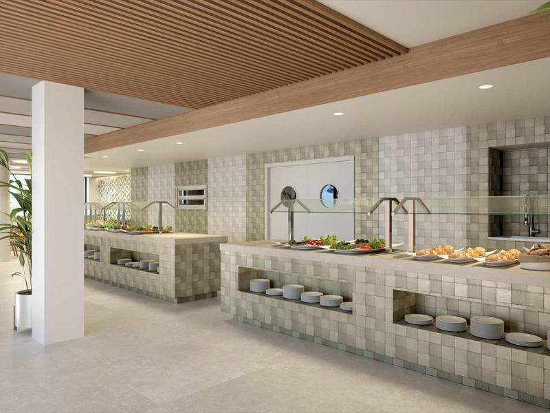 Moderner, heller Küchenbereich mit großem Tresen, weiß-grauen Fliesen und Holzdach.