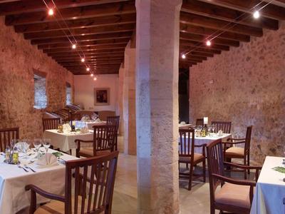 Przytulna restauracja z kamiennymi ścianami, drewnianym stropem i ciepłą atmosferą.