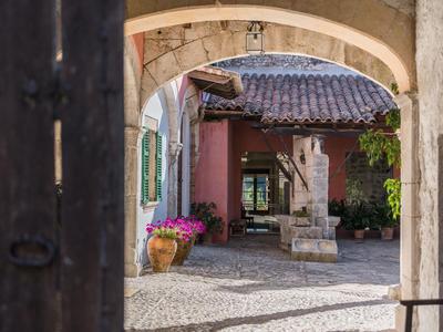 Charmanter Innenhof mit Steinbogen, Pflastersteinen und Blumentöpfen in einem Hotel.