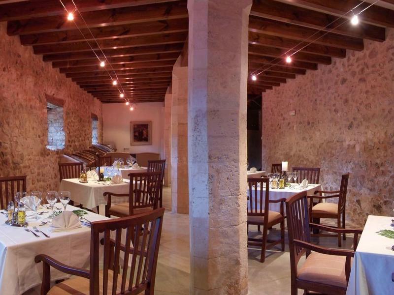 Przytulna restauracja z kamiennymi ścianami, drewnianym stropem i ciepłą atmosferą.