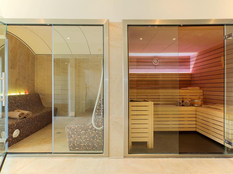 Nowoczesna strefa wellness z sauną i pokojem wypoczynkowym z kanapą w hotelu.