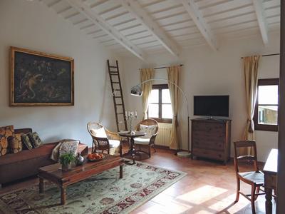 Salon chaleureux avec cheminée, plafond en bois et coin salon dans une chambre d'hôtel
