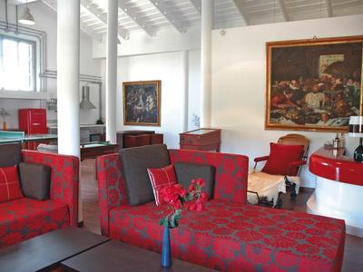 Moderně zařízená hotelová lounge se červenými křesly a stylovým uměním na zdech.