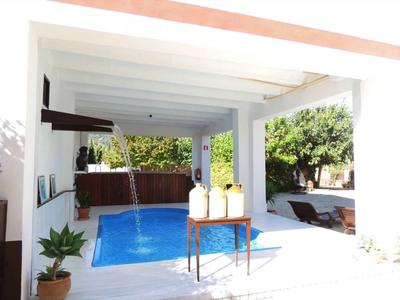 Piscine extérieure moderne avec patio élégant et environnement verdoyant.
