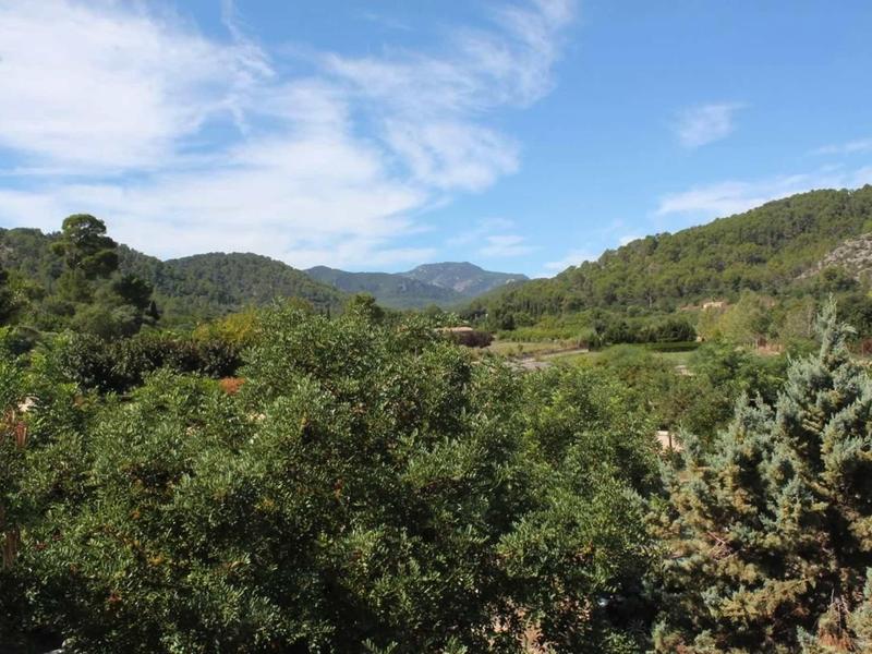 Zelené kopce pod modrou oblohou s rozptýlenými mraky.