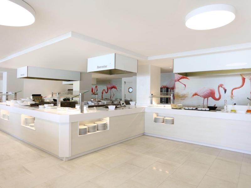 Moderne weiße Küche mit großem Kochfeld, Arbeitsflächen und Flamingo-Wanddekor.