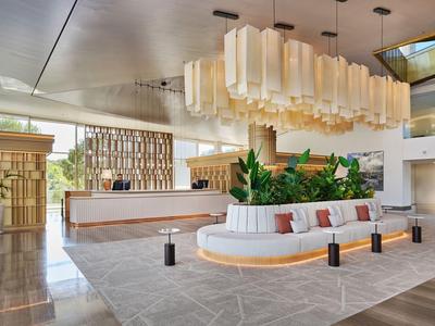 Moderna hall d'hotel con grande lampadario e zona salotto accogliente.