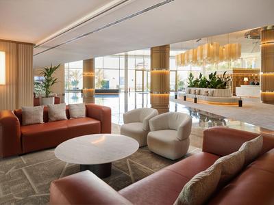 Elegante area soggiorno dell'hotel con divani accoglienti, poltrone e arredamento moderno.