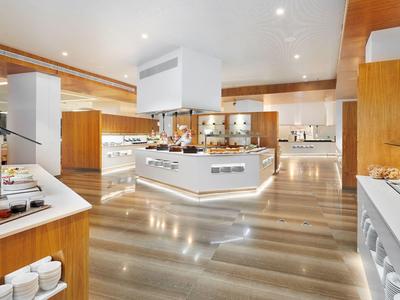 Interno di una cucina d'hotel moderna e ben illuminata con pavimenti lucidi.